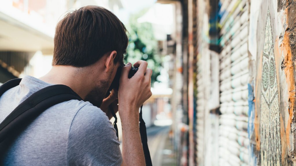 jovem fotografando na rua